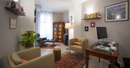 Stanza dei colloqui con poltrone, libreria e scrivania