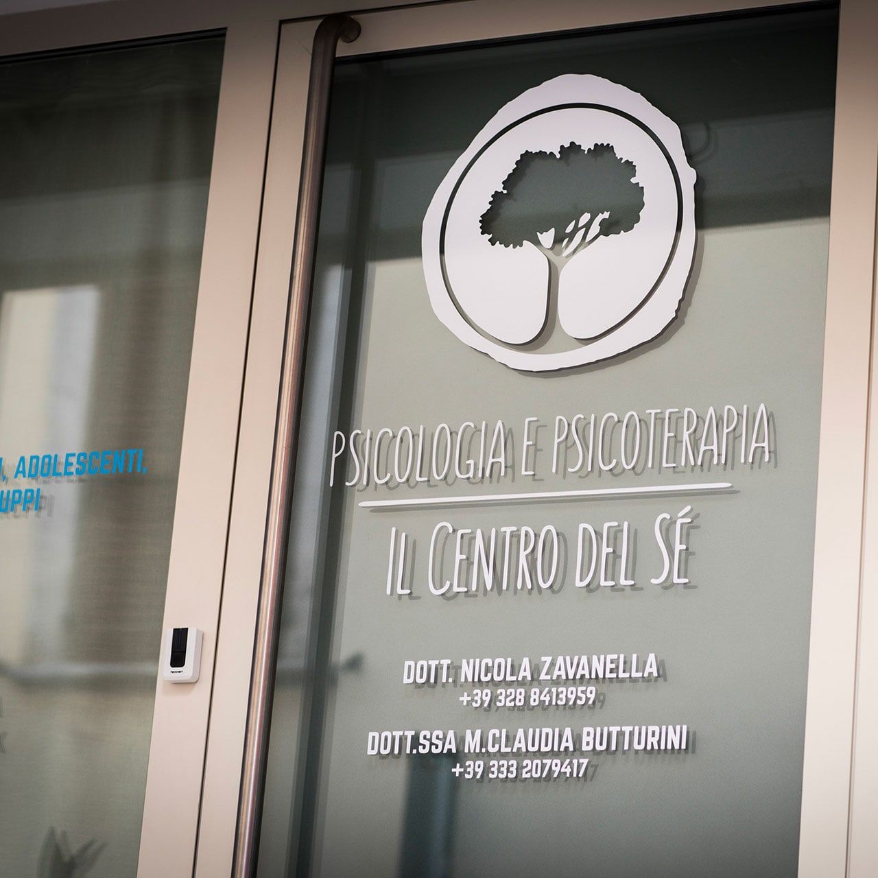 Vetrata dello studio con il logo dell’albero, la scritta Psicologia e psicoterapia e i nomi dei professionisti